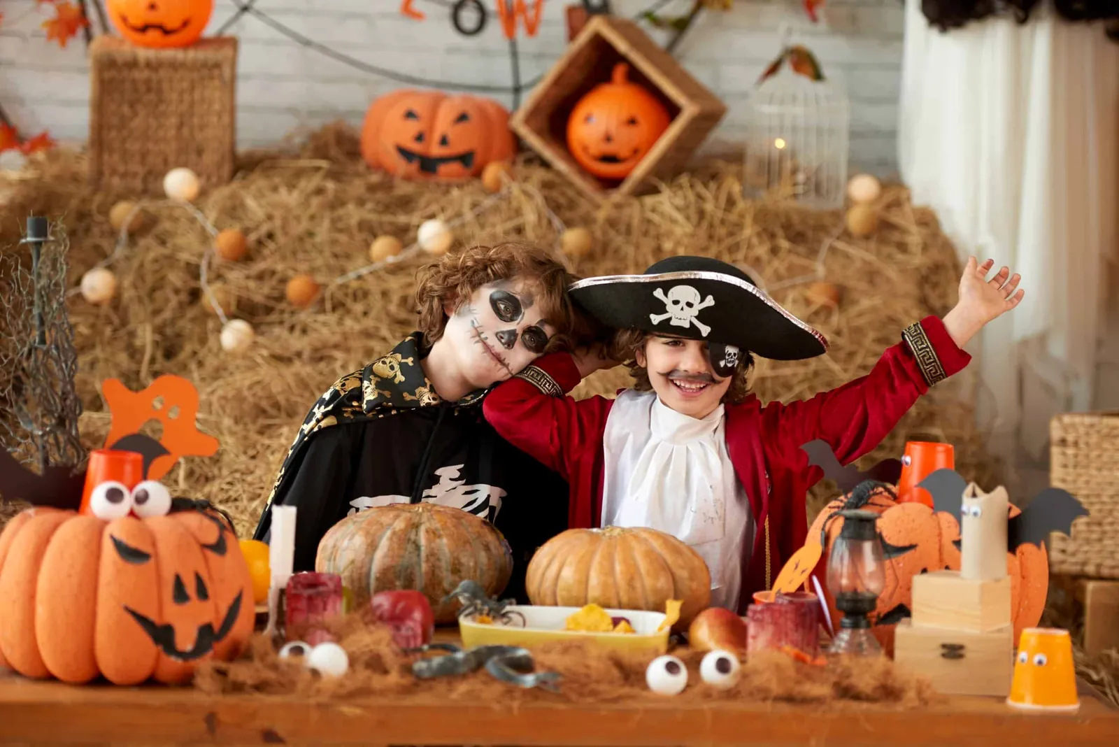 Crianças fantasiadas de pirata e caveira em festa com decoração de abóboras — Buffet Infantil Cozinha Boêmia